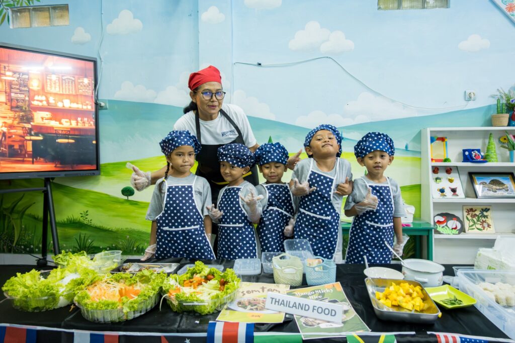 Siswa berperan sebagai penjual di salah satu stan makanan, menyiapkan dan menawarkan produk kepada pembeli.